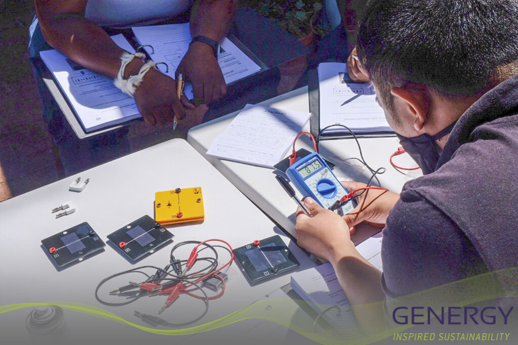 People looking at Voltage metres at training with writing: GENERGY Inspired Sustainability