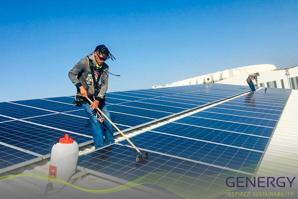 Men washing solar panels on rooftop with writing: GENERGY Inspired sustainability and green lines at bottom of image