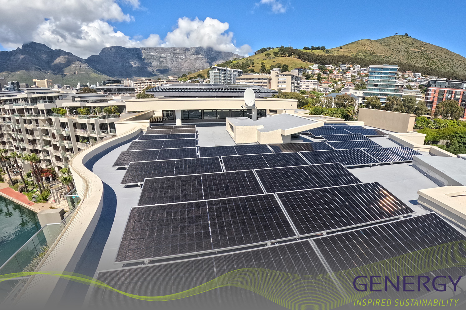 Solar panels on rooftop in Cape town waterfront with Table Mountain in Background and green lines swoosh at bottom of image with writing in bottom right corner: GENERGY, Inspired sustainability