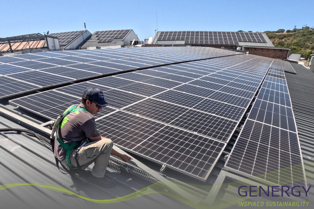 Man on rooftop crouching in fron of solar panels with green lines at bottom of image and writing in bottom right corner: GENERGY, Inspired sustainability