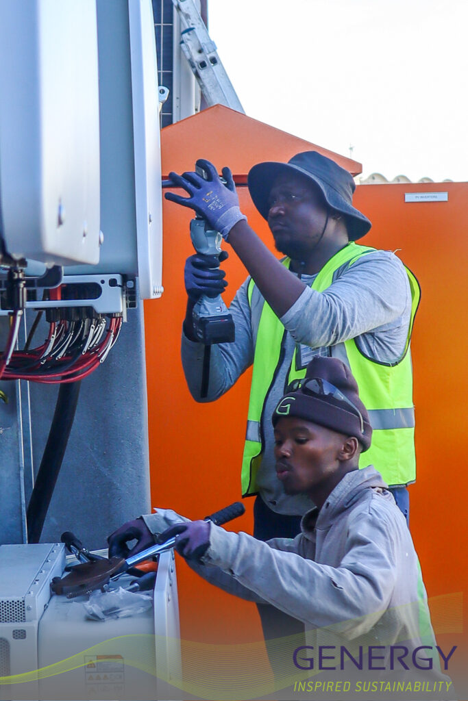 Two workers working on a DB board with lines at bottom of image and writing in bottom right: GENERGY, Inspired Sustainability
